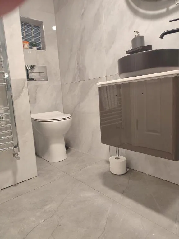 Bathroom with marble-effect tiling, WC and vanity sink