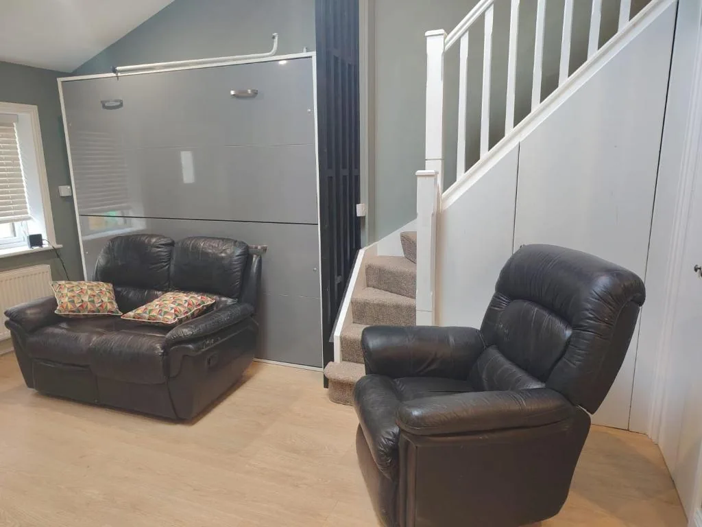Living area showing the fold-down bed unit and staircase