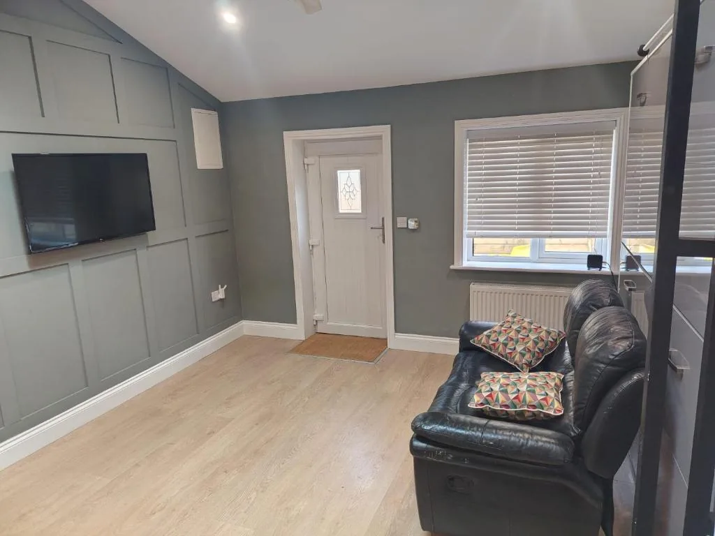 Living area with reclining sofa and wall-mounted TV